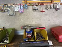 Overview of two bins containing wrenches and sockets on a workbench with wall pegboard above