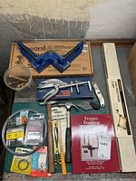 Overall view of framing tools including clamps, brad driver, chisels, book