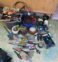 Full overview of gardening tools, hand trowels, cultivators, pruners, rakes, watering cans, pots, watering timers, mosquito rackets, and gloves.