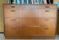 Front view of mid-century modern 4 drawer wood bookcase showing drawer layout and wear.