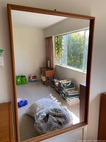 Front view of rectangular teak framed wall mirror.