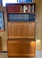 Front view of the assembled three-piece teak shelving and cabinet unit