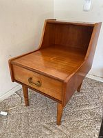 Three different angled photos of a mid-century modern style wooden side table with a single drawer and tiered back panel, showing the front, angled front and top surfaces with visible scratches and scuffs.