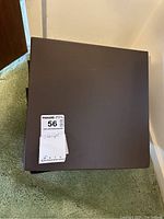 Photo of the closed large black binder for holding the stamp collection, with auction tag '56' and label 'stamps'.