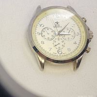 Front close-up of men's B&R quartz chronograph watch case showing cream dial, Arabic numerals, three subdials, and silver-tone round casing.
