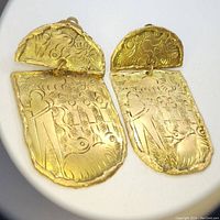 Pair of large gold-toned handmade engraved earrings showing the full design details of each earring.