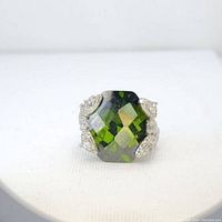 Front view showing large green faceted garnet and clear stone prong setting