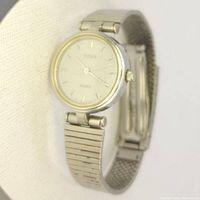 Front view of Titan watch face showing minimalist white dial with gold accent and silver markings.