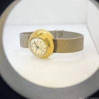 Side angled close-up showing the barrel grained golden case with crown and detailed mesh bracelet of the Timex watch.