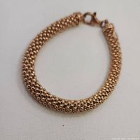 Close-up of the rose gold vermeil 925 bracelet showing the woven mesh design and lobster clasp.