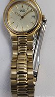Front view of the gold-tone Seiko watch with gold dial and date display at 3 o'clock.
