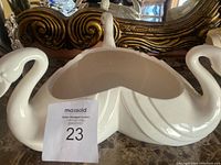 Top view showing the swan-shaped white porcelain bowl with two swan heads forming the handles and a wide shallow bowl in the center.