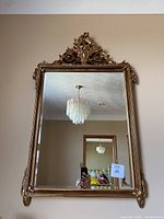 Front view of full mirror showing carved gilded frame and reflective glass