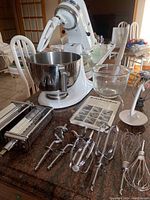 Overview of white KitchenAid stand mixer with attachments and bowls on countertop