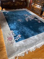 Full view of the rug on hardwood floor showing overall design, field and border