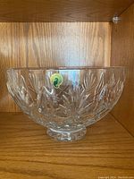 Clear crystal Waterford bowl showing full side profile on wooden shelf with sticker visible.
