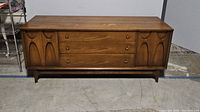 Front view of walnut veneer credenza showing carved pulls and door fronts