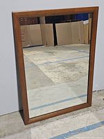Front view of rectangular mirror showing wood frame and reflective glass surface