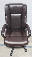 Front view of the brown leather office chair showing cushioned seat, backrest, and armrests.