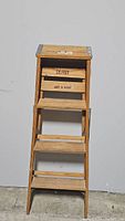 Front view of the wooden ladder showing four steps and Derby branding