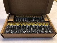 Opened box showing rows of packed AA and AAA NANFU performance alkaline batteries, black with silver and gold tops.