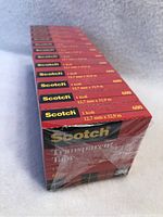 Photo of 12 stacked sealed boxes of Scotch Transparent Tape 12.7mm x 32.9m, model 600.