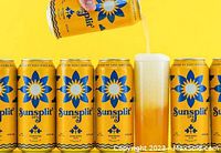 Row of yellow Sunsplit IPA cans with one being poured into a glass