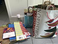 Photo showing a variety of gift bags including Nordstrom, holiday-themed, striped, and solid color bags.