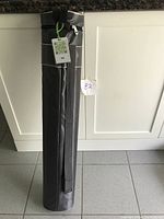 Black nylon carrying case stored upright with zipped closure and strap