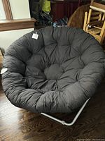 Front view of the large black saucer chair showing cushioned cotton seating.