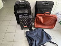 Front view showing front pockets, handles, and colors of all five luggage pieces.