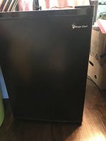 Front view of the mini bar fridge showing the black finish and Magic Chef logo.