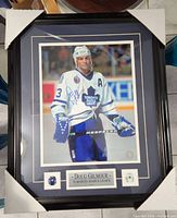 Framed autographed Doug Gilmour photo in Toronto Maple Leafs uniform with protective corner covers on frame.