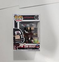 Front view of Tom Brady Funko Pop #157 in original packaging showing the figure and branding.