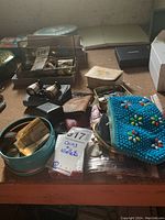 Overall view of the lot showing tins with coins, binoculars, coin purses, and wallets arranged on a surface.