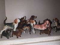 Front view showing various porcelain dog figurines in assorted breeds and colors with glossy finishes