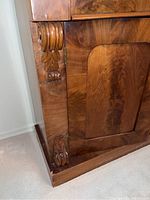 Close-up view of corner carved wood detail on sideboard cabinet illustrating wood finish and condition.