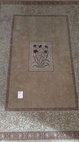 Full view of beige carpet with red tulip design and geometric border pattern