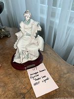 Front view of Giuseppe Armani figurine titled 'Tender Love' seated on wooden base with artist name plaque and handwritten note confirming signed status.