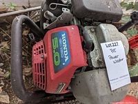 Close-up of red Honda engine housing showing 5.0 HP label and Lot tag