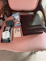 View of all items including wooden jewelry box, blue box with bracelets and watches, white wired earbuds, Fitbit wristband box, and smaller black box on chair.