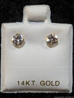 Front view of 14K gold cubic zirconia stud earrings displayed on a white holder labeled 14KT GOLD.
