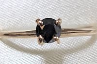Front view of the solitaire ring showing round black diamond in prong setting