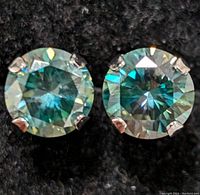 Close-up photo of the pair of round cut Moissanite stud earrings set in 10K white gold with four-prong settings, showing stone clarity and sparkle.