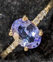 Front view highlighting the oval tanzanite center stone and diamond accents on the band