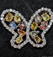 Front view of butterfly brooch showing mixed-color sapphires and CZ outline