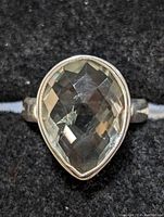 Close-up front view of the sterling silver ring with pear-shaped green amethyst gemstone showing the faceted cut and bezel setting.