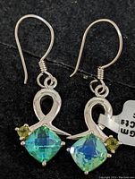 Front view of both earrings showing the green mystic stones and silver setting.