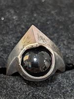 Close-up of the sterling silver ring front view showing the large black onyx stone in a bezel setting, with noticeable tarnish on the silver band.