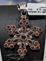 Front view of the star-shaped pendant showcasing multiple round and marquise garnet stones set in sterling silver.